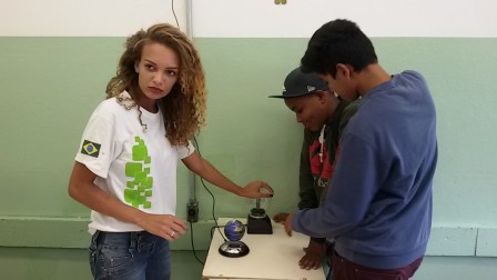 Aline apresenta o levitador magnético e a bola de plasma aos alunos