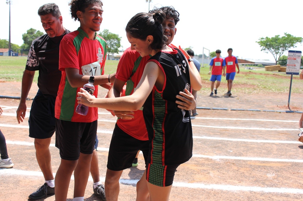 Imagem 1 - Alunos Mitcy, Kauã e Davy e o chefe da delegação Prof Ibsen comemorando o resultado no atletismo