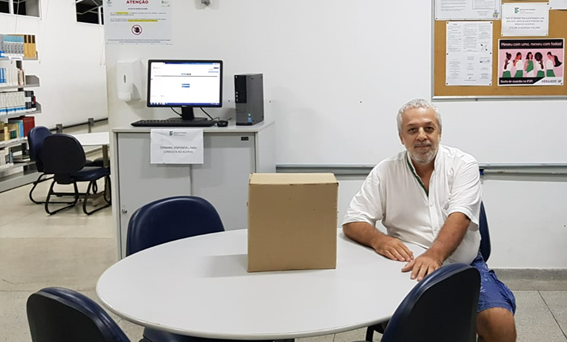 Imagem 5 – Professor Ricardo com caixa de livros doados para a biblioteca