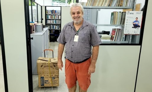 Imagem 3 – Professor Ricardo na Biblioteca com as caixas com os livros doados