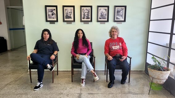 Imagem 6 – Michele, Yasmin e José Humberto em frente a fotos de importantes físicos