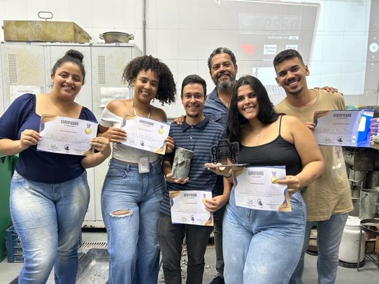 Imagem 2: Equipe detentora do recorde de resistência do concreto, com Laiza, Ingrid, José Geraldo, Bruna, Anderson, e Prof. José Américo ao fundo