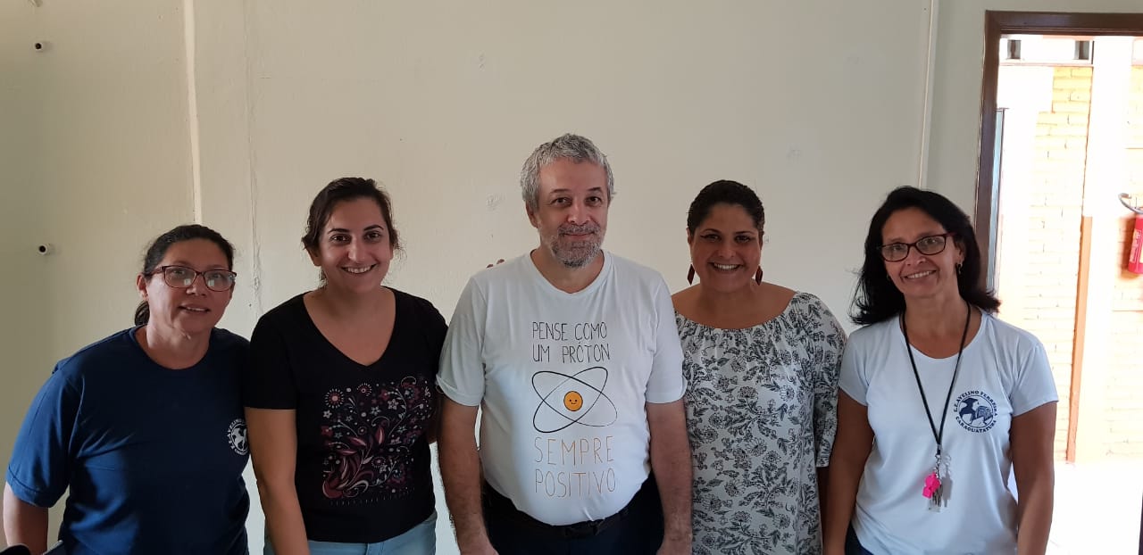 Professor Ricardo junto com docentes na sala dos professores da Escola Avelino