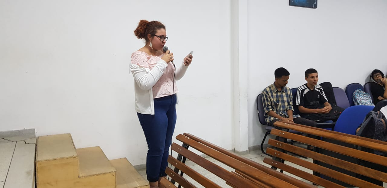 Foto: Larissa lendo uma poesia no final da palestra