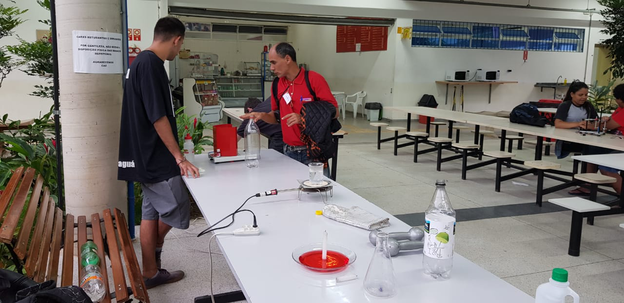 Foto: Estudante de física explica experimento exposto no pátio