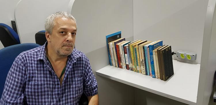 Professor Ricardo Plaza junto a alguns dos livros que foram doados