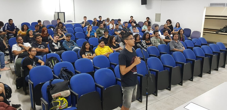 Foto Estudante de física Erik faz uma pergunta para a física Gabriela Bailas