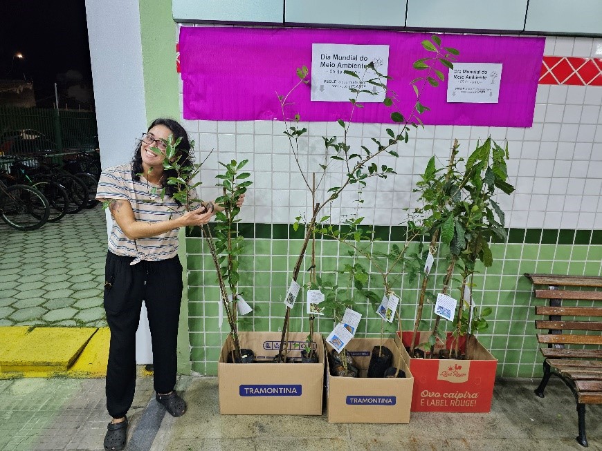 Imagem 1: aluna Marcella Uehara organizando as mudas na entrada do campus