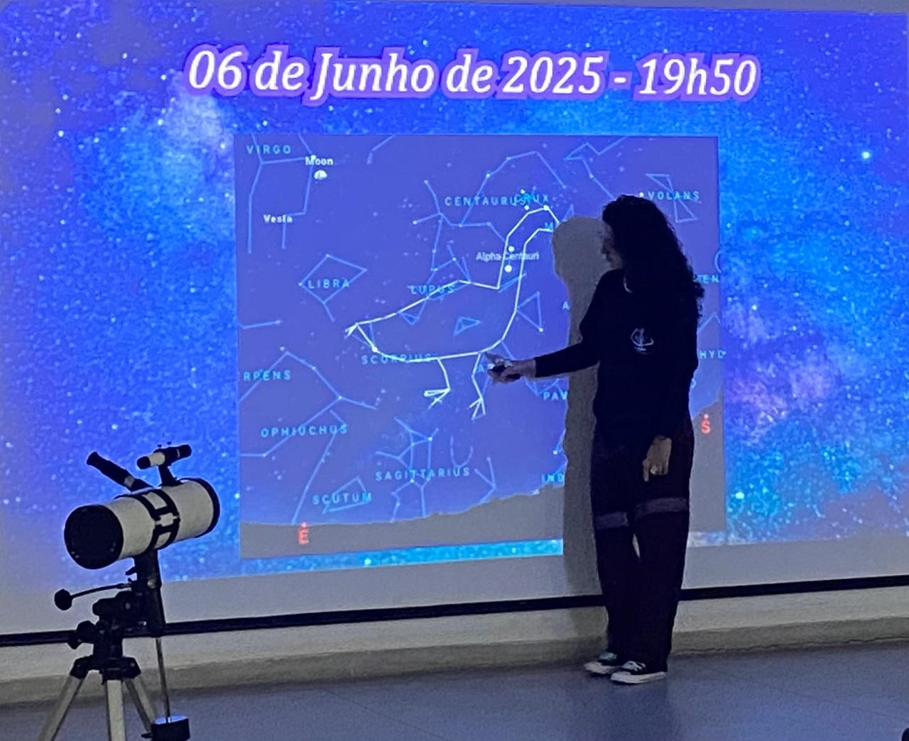 Imagem 2: A aluna Bruna Nunes, do 7o semestre do curso de Licenciatura em Física, apresentando sua palestra sobre astronomia dos povos indígenas. Na imagem, a apresentadora aborda a constelação da Ema, conhecida por povos indígenas brasileiros
