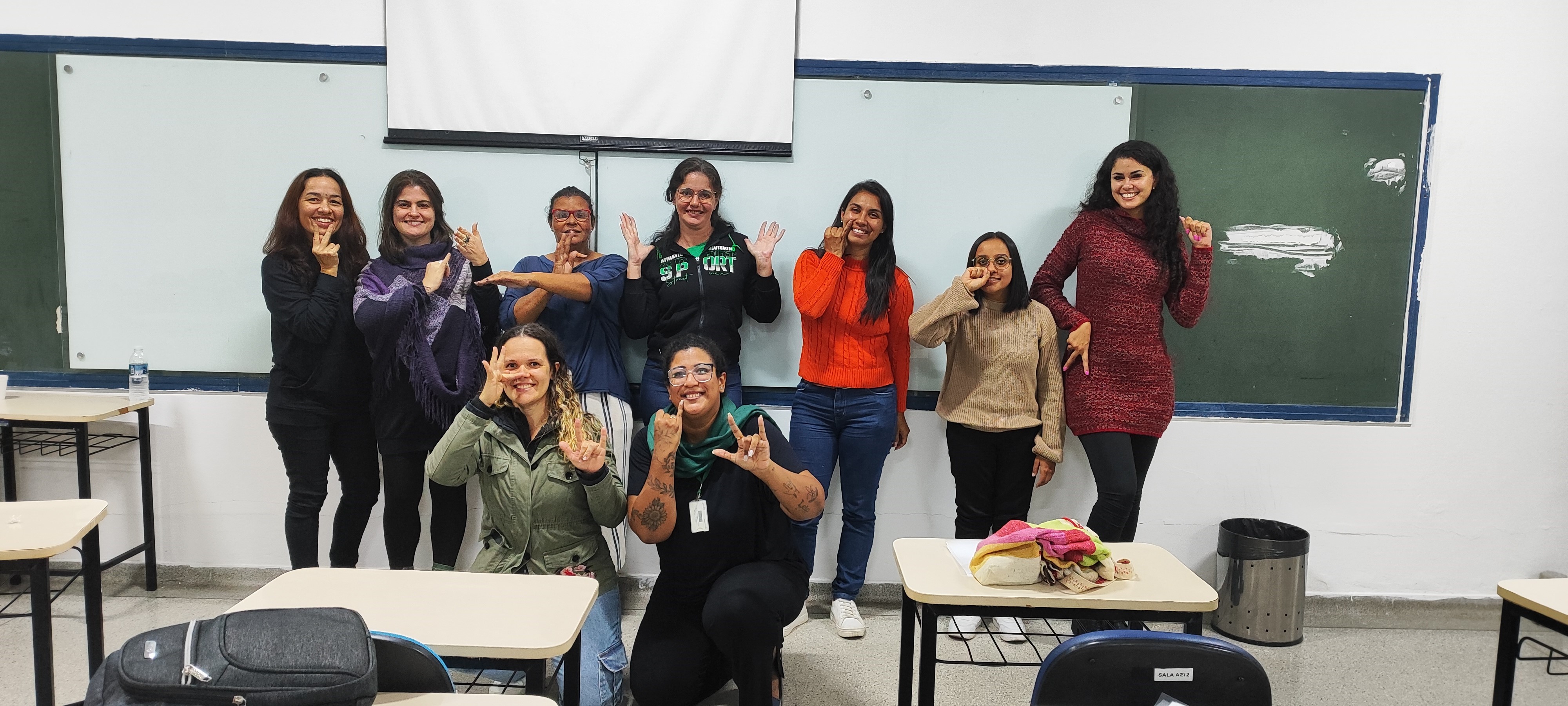 Imagem 5: Participação da Convidada Surda - Alunas, Prof.ª Izabela e Flora posam fazendo seus “Sinais  Pessoais” que receberam na aula.