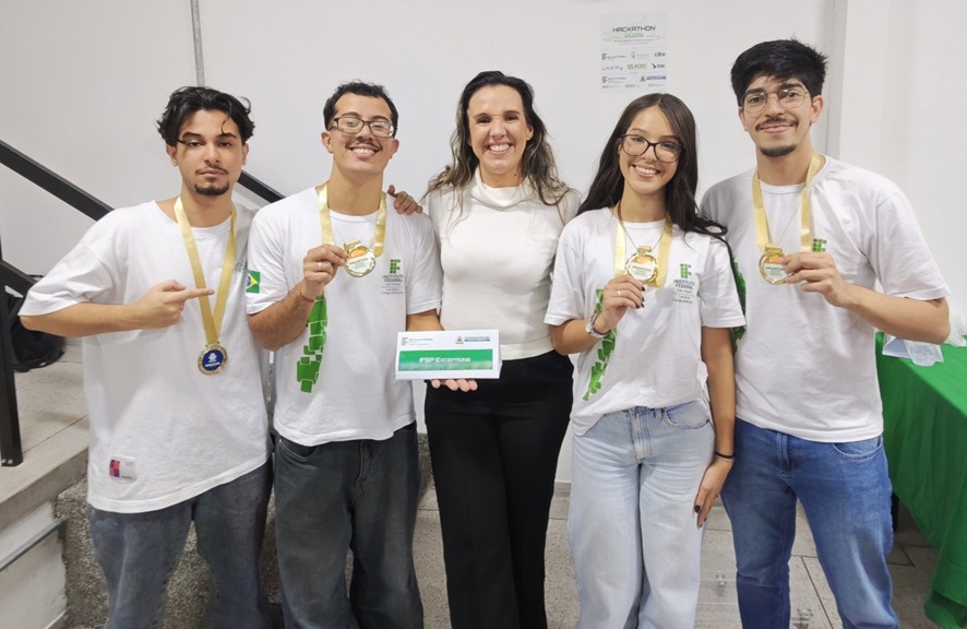 Imagem 7: Prof.ª Juliana, coordenadora do curso de ADS do IFSP-CAR com a equipe campeã do Hackathon 2026.