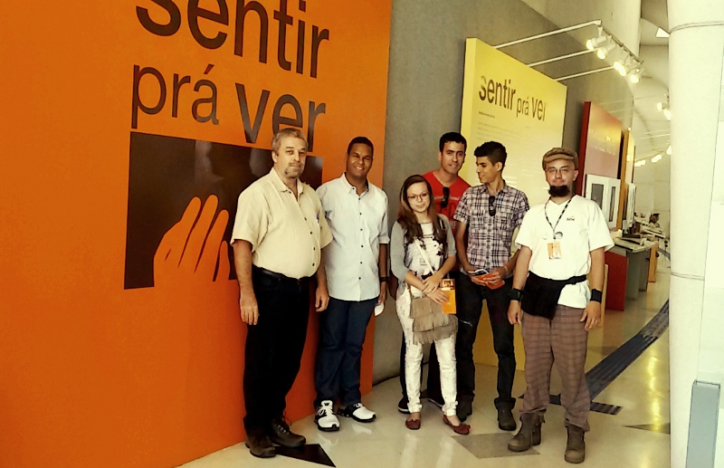 Professor Ricardo, estudantes do IFSP e educador Igor na entrada da exposição “Sentir prá ver”