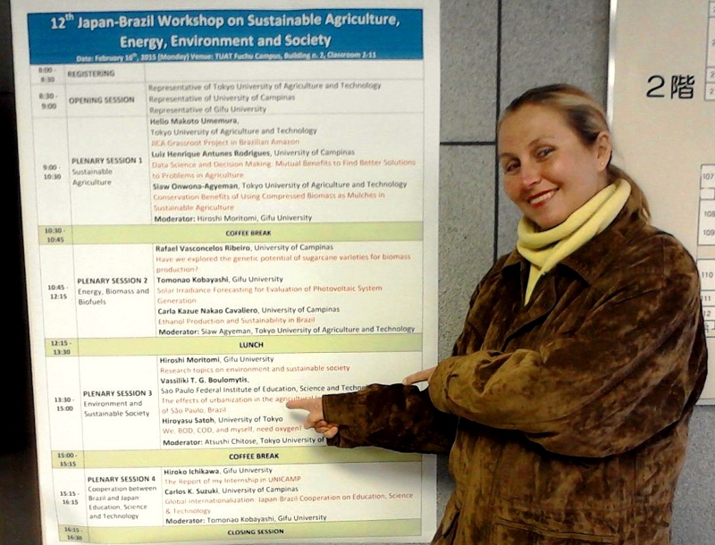 Professora Vassiliki em frente à programação do evento