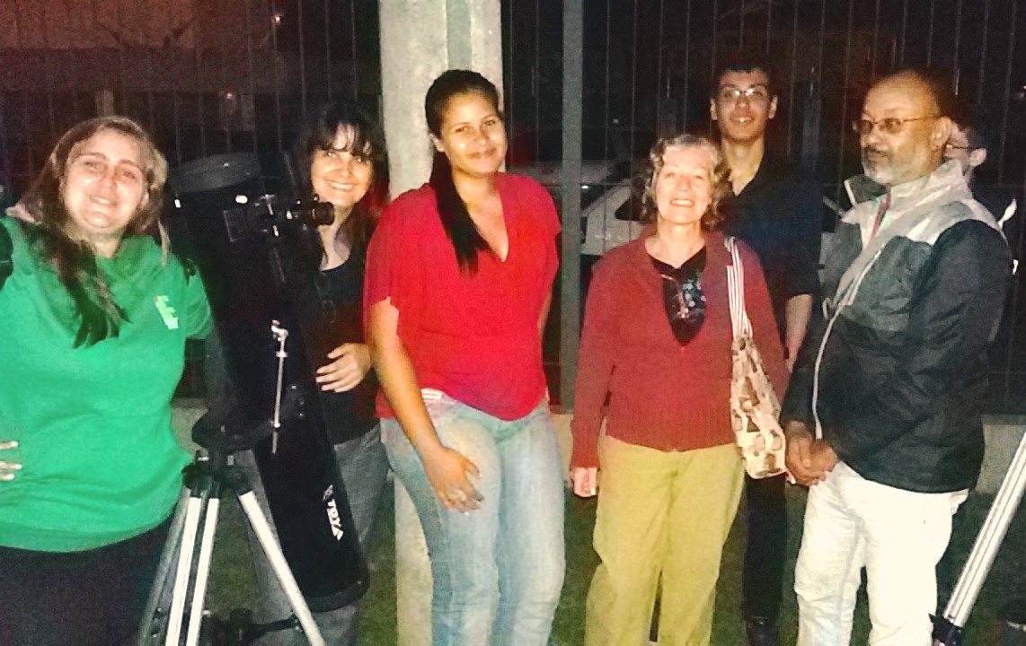 Telescópio refletor em frente de alguns dos presentes