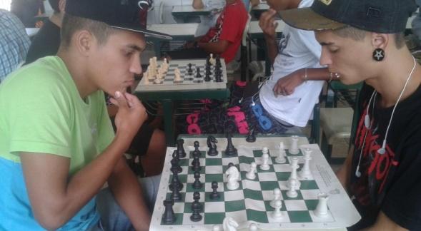 Dois alunos em momento de concentração durante um jogo do minicurso de xadrez