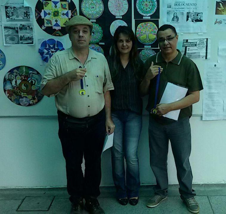  Professor Ricardo e Adriana entregam uma medalha para o professor Luis Américo Monteiro Junior 