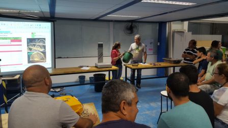 Alunos reunidos observam a preparação para mais um ensaio destrutivo de uma ponte de macarrão