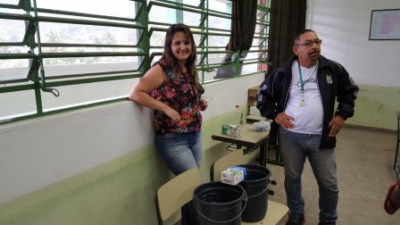 Adriana e professor Edward em frente à experiência de física