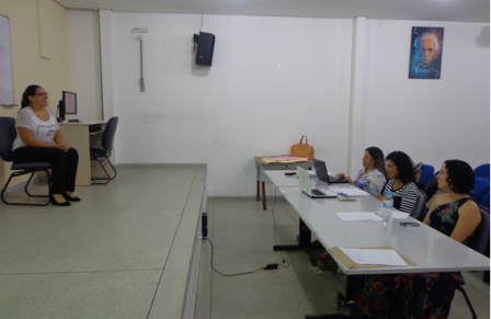 Pamela apresentando seu trabalho para as professoras Marta, Amanda e Natália